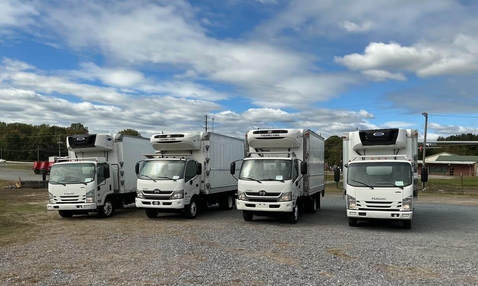 Four White trucks sitting in a line